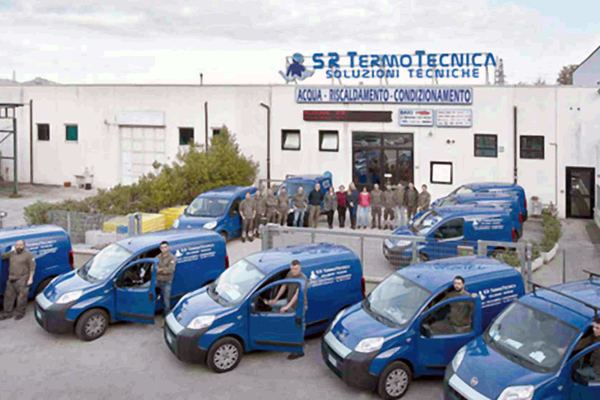 La sede di S.R. Termotecnica con l’insegna «Acqua – Riscaldamento – Condizionamento» e i furgoni aziendali schierati davanti