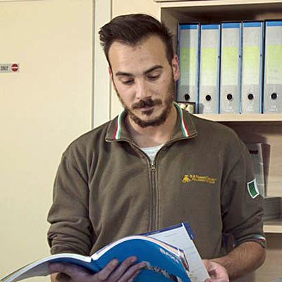 Un tecnico in divisa S.R. Termotecnica sfoglia un catalogo in ufficio